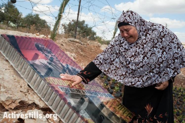 Sabiha, Bassem's mother, weeps over a photograph of her son